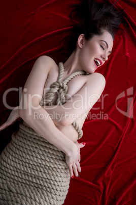 Image of pleased woman tied with jute rope