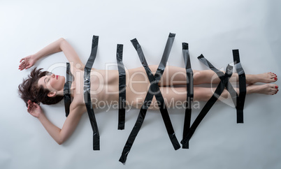 BDSM concept. Nude woman with black adhesive tape