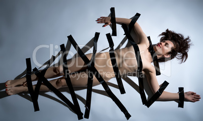 Concept. Naked body of girl covered with duct tape