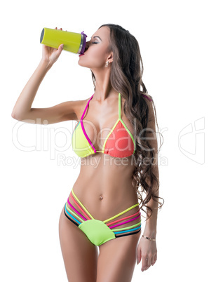 Pretty girl in sexy bikini drinks sports beverage