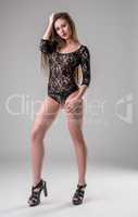 Studio photo of sexy leggy model in lace bodysuit