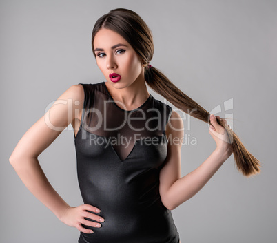 Sexy brunette in bodysuit posing as femme fatale