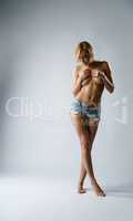 Seductive nude woman posing in denim shorts