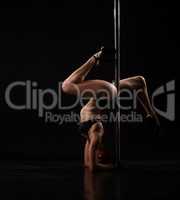 Seductive dancer doing handstand to pylon