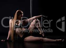 Sexy clubbing dancer posing with pylon in studio