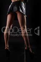 Slender legs of pole dancer in high heels