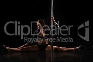 Studio photo of flexible pole dancer doing split