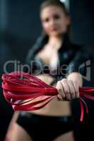 Image of pink whip in dancer's hand, close-up