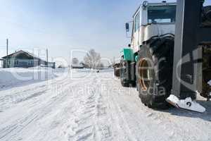 Tractor rides through village in winter