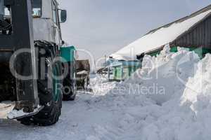 Winter time. Tractor cleans snow in village