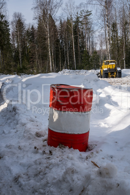 Image of barrel and working snowplow on backdrop