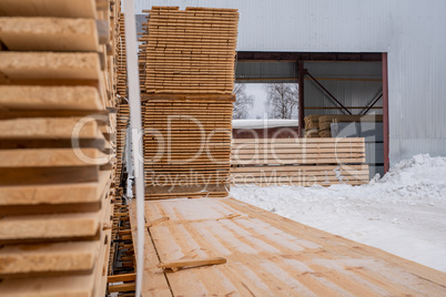 At sawmill. Boards stacked outside in winter time