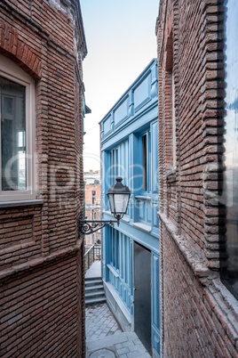 Narrow street and lantern on wall of building