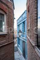 Narrow street and lantern on wall of building