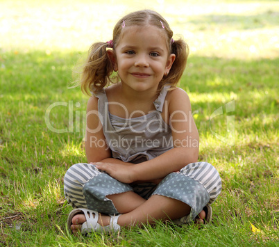 little girl sitting on grass