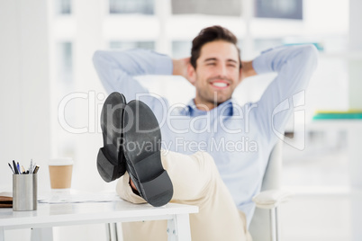 Thoughtful man sitting with feet on table