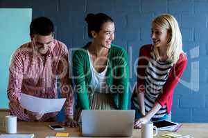 Colleagues discussing at desk