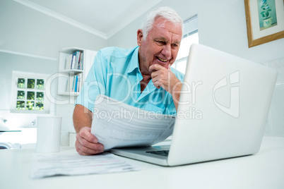 Smiling senior man looking into laptop