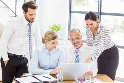 Business colleagues discussing office work on laptop