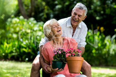 Senior couple with flower pots in yard