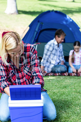 Woman looking into the cool box outside the tent