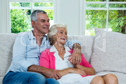 Senior couple looking away at home