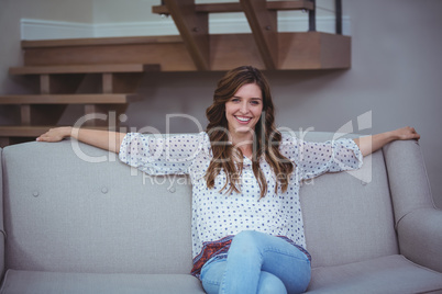 Portrait of beautiful woman sitting on sofa