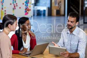 Team of colleagues discussing at their desk