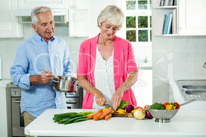 Happy senior couple preparing vegetables