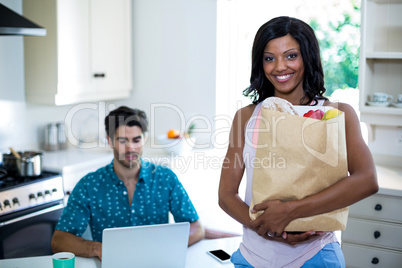 Portrait of woman standing with a bag of groceries