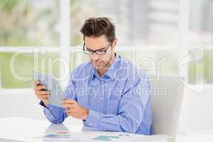 Businessman looking at document and using digital tablet