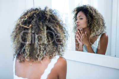 Woman checking her skin in bathroom