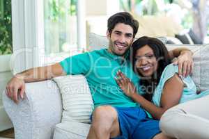 Portrait of happy young couple embracing each other on sofa