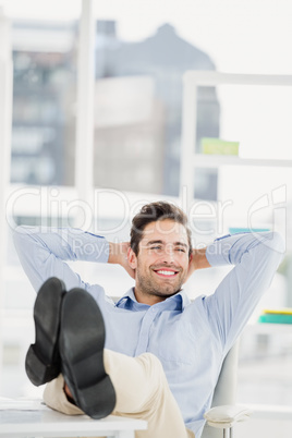 Thoughtful man sitting with feet on table