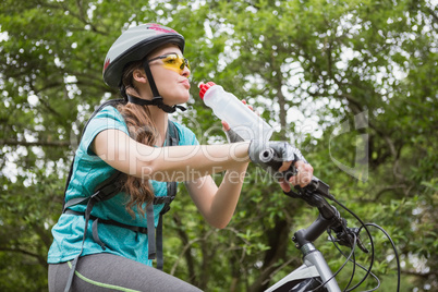 Woman drinking water while cycling