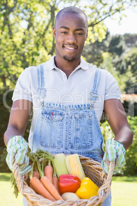 Young man holding a basket of freshly harvested vegetables