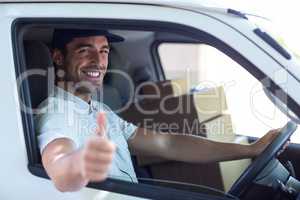 Delivery man showing thumbs up while driving van