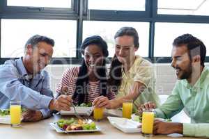 Colleagues having breakfast in office