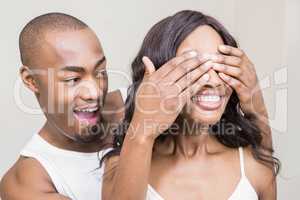 Young man covering womans eyes
