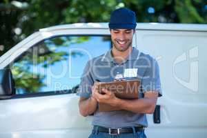 Smiling delivery person writing in clipboard