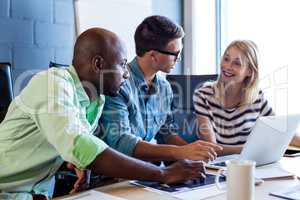 Colleagues discussing at their desk