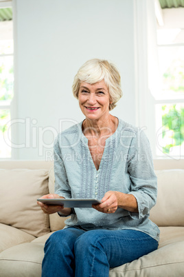 Portrait of smiling senior woman with digital tablet