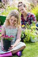 Girl sitting in garden with flower pot