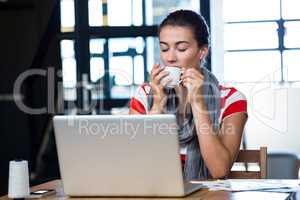 Woman having coffee at desk