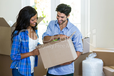 Young couple unpacking carton boxes