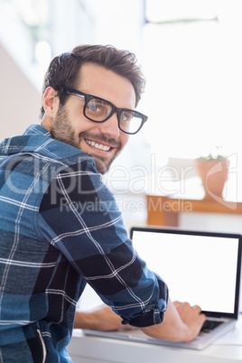 Happy young man using laptop at home