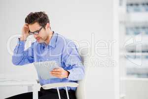 Businessman looking at document and using digital tablet