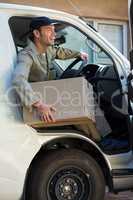 Smiling delivery man getting out from van