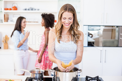 Woman preparing spaghetti noodles in kitchen