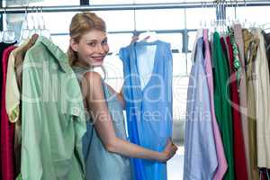 Woman selecting an apparel while shopping for clothes